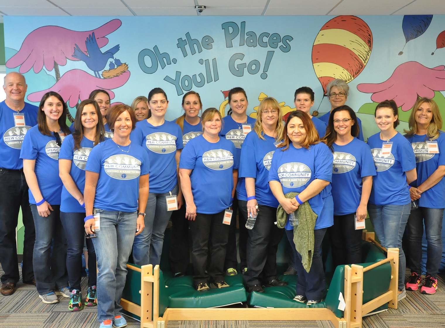 A group of people in blue t - shirts standing in a room with dr seuss.