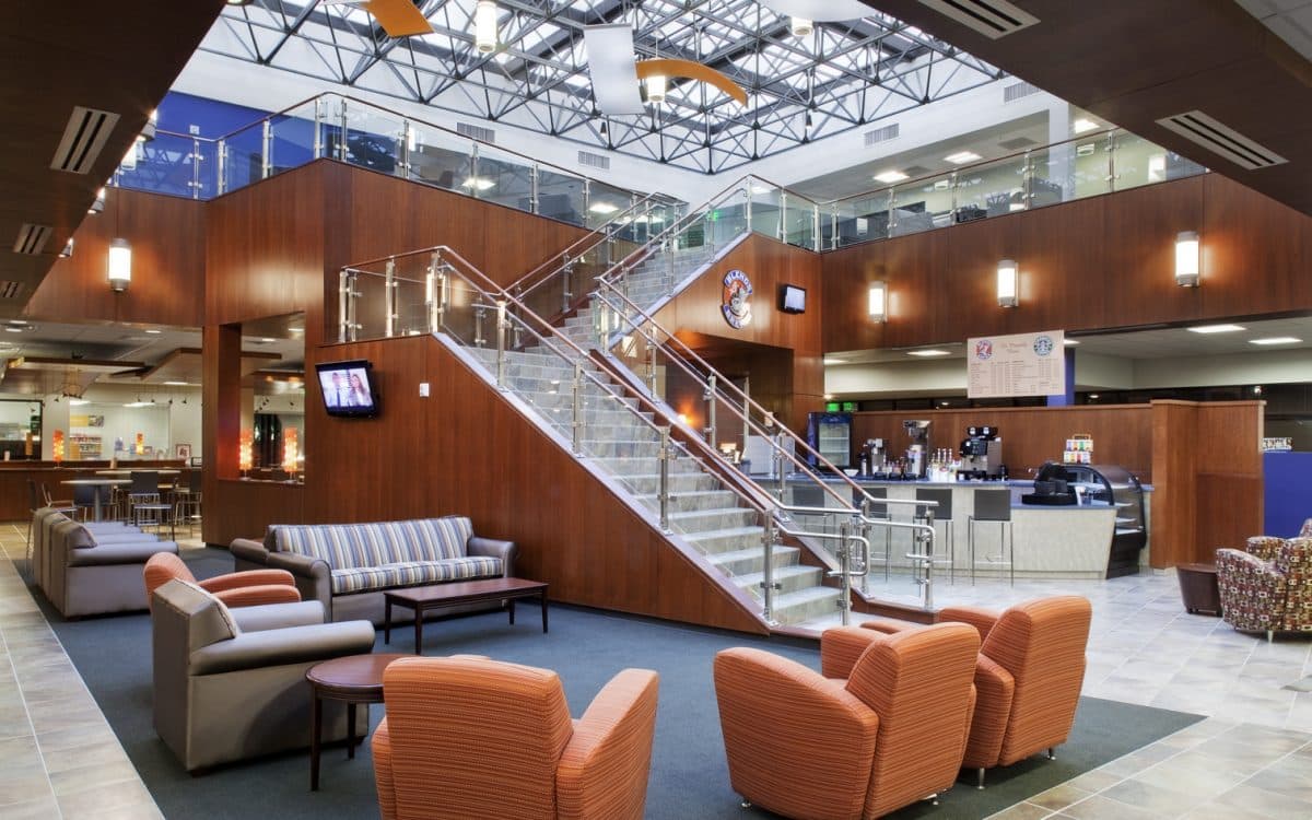 A lobby with couches, chairs and a staircase.