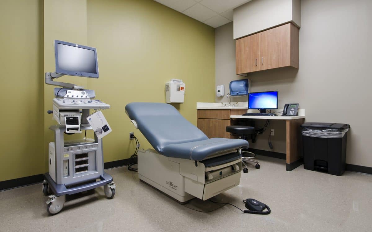 A medical room with a computer and medical equipment.