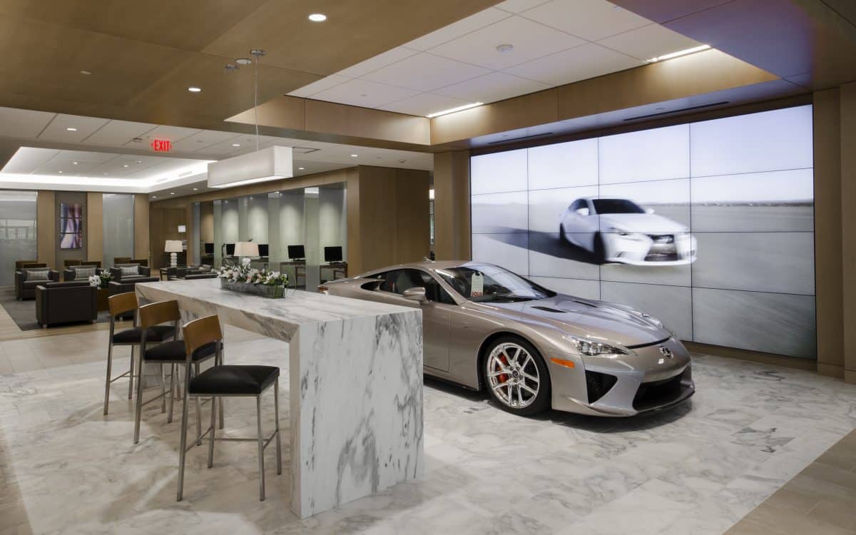 A lexus dealership with a sports car in the lobby.