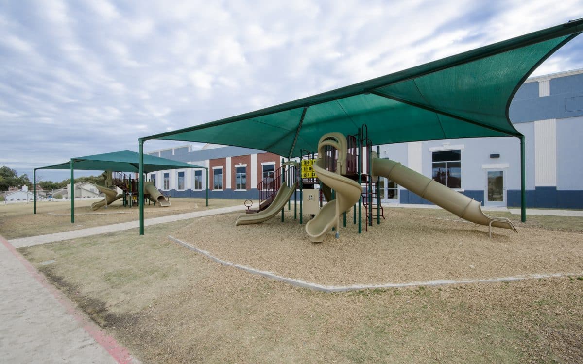 A playground with a green canopy.