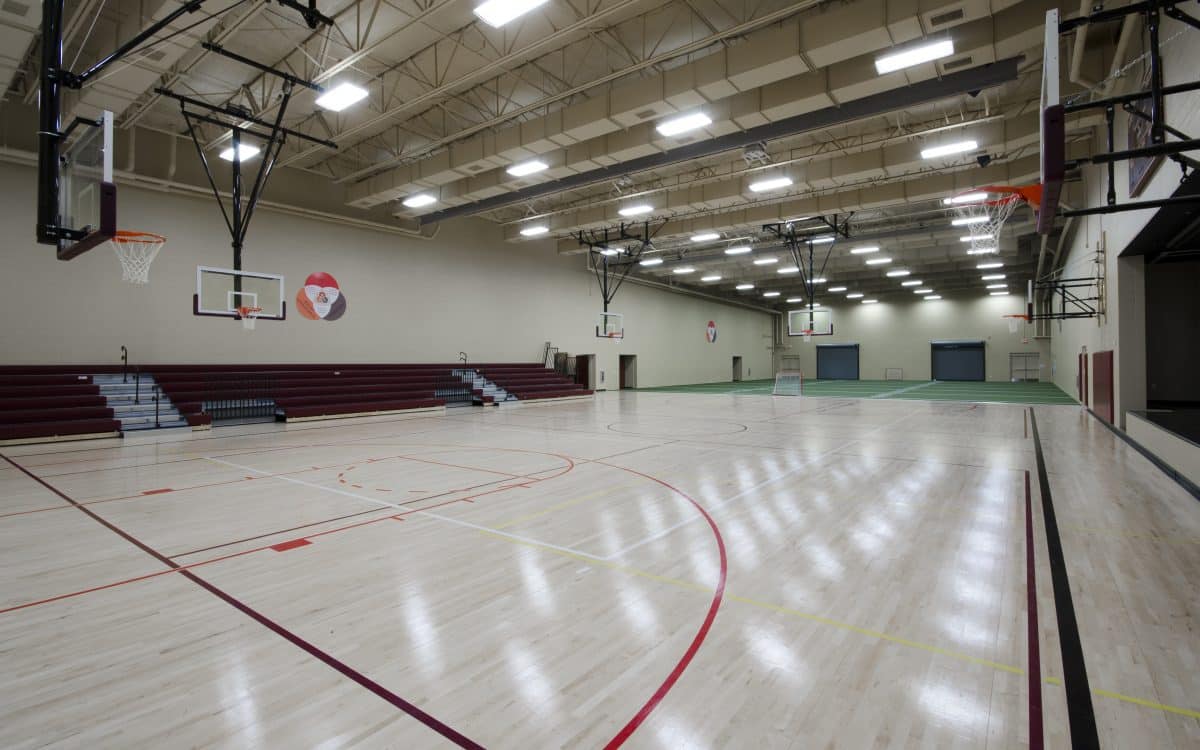 A gymnasium with a basketball court and bleachers.
