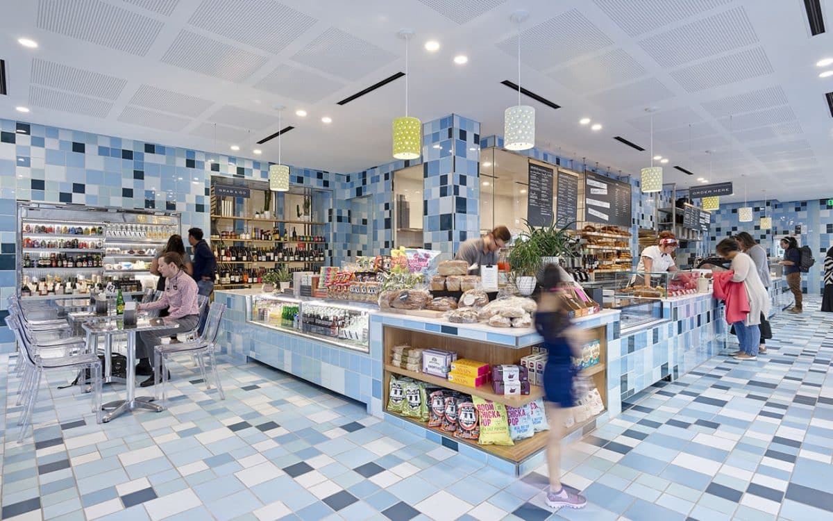 A blue and white tiled store with people in it.
