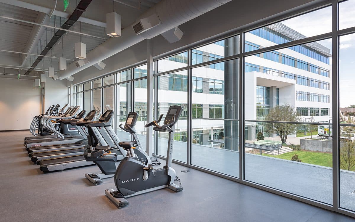 A room with exercise bikes and windows.