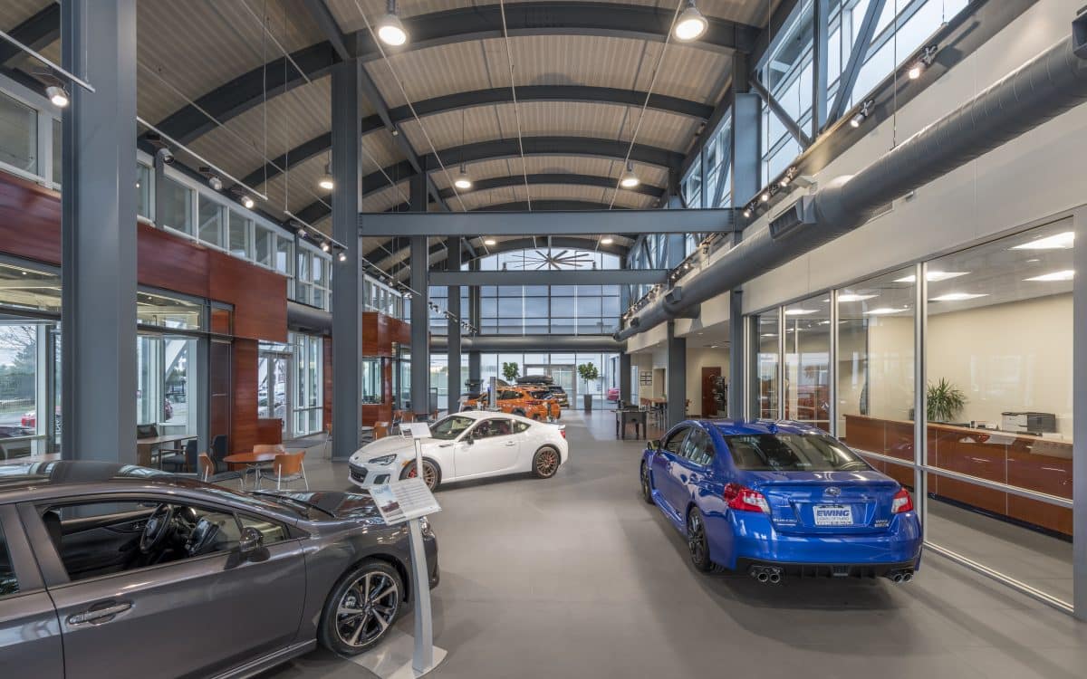 The interior of a car dealership with several cars parked inside.