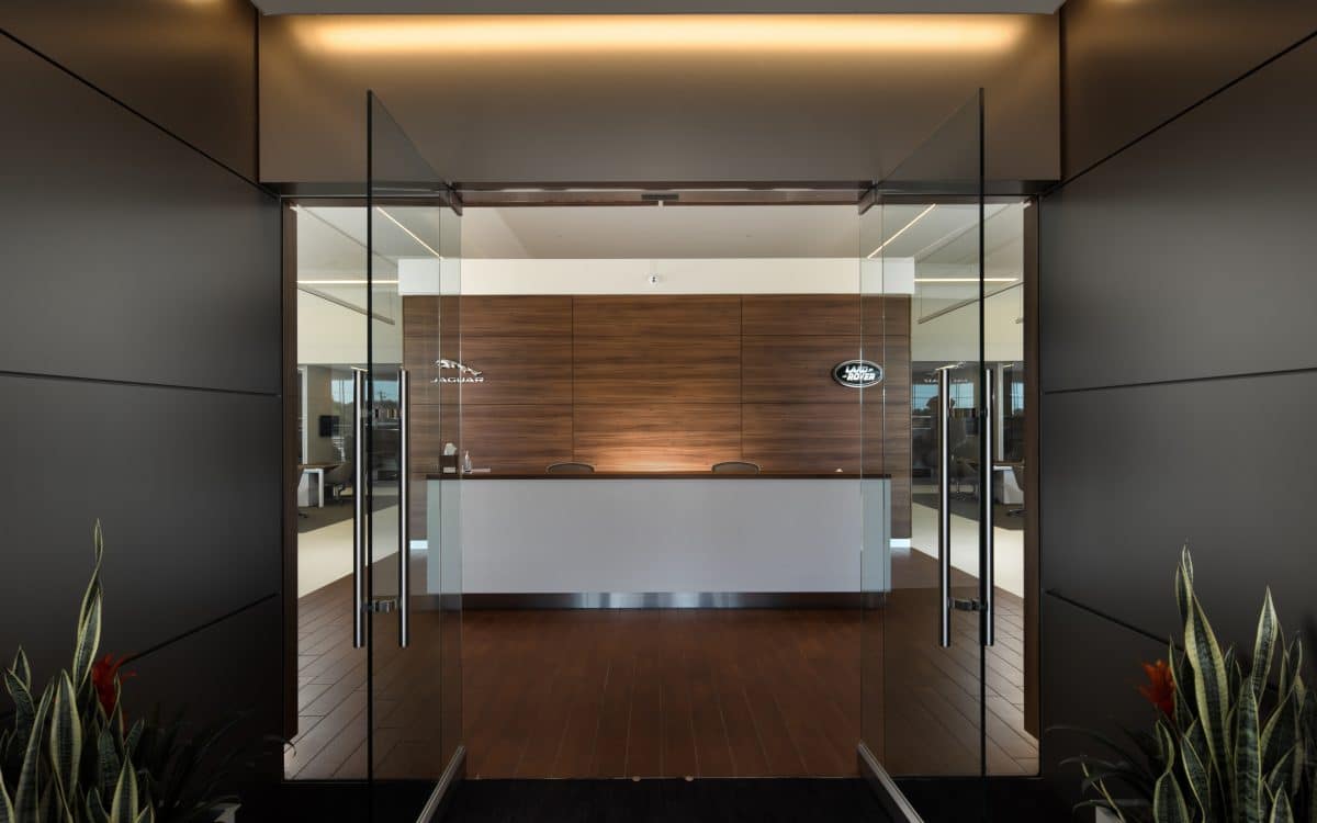 A modern office with glass doors and a wooden floor.