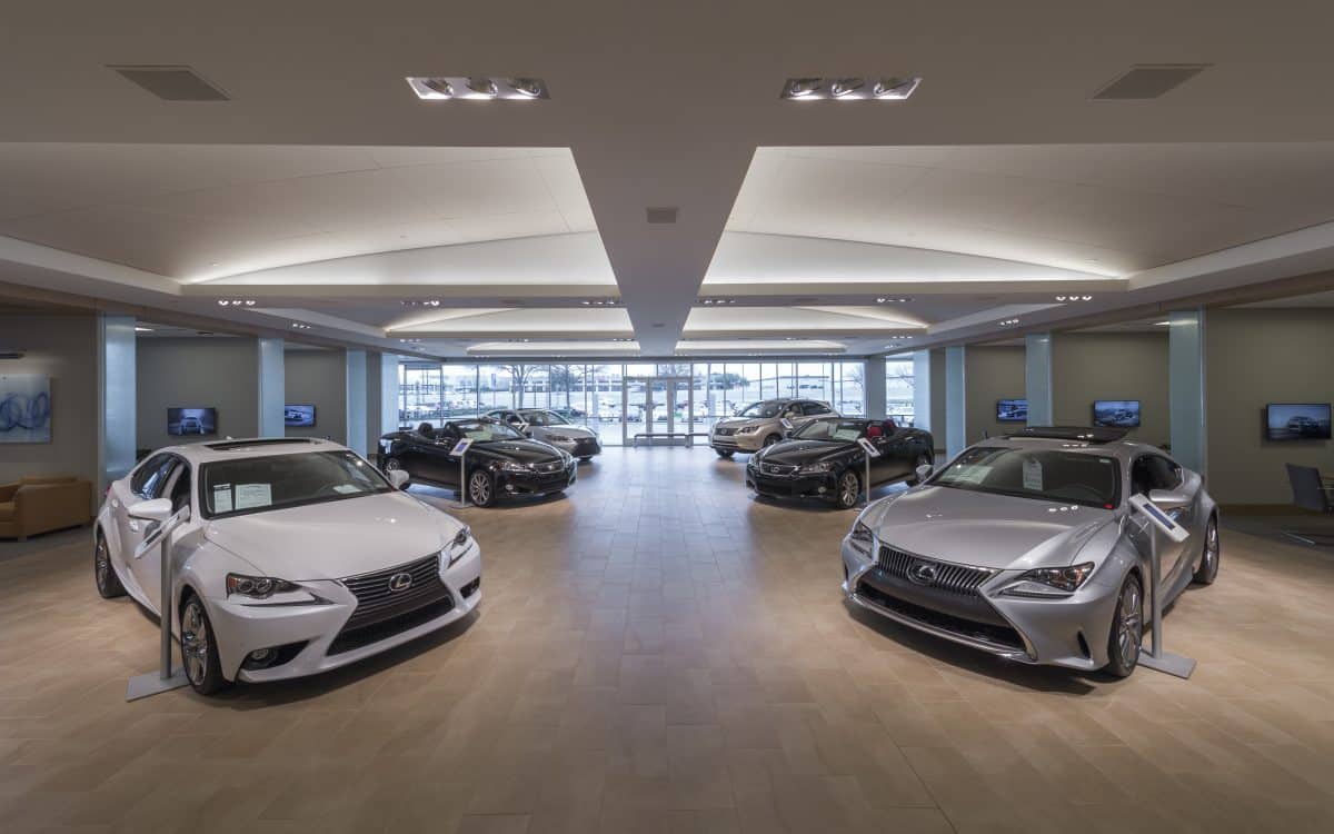 A lexus dealership with several cars parked in the showroom.