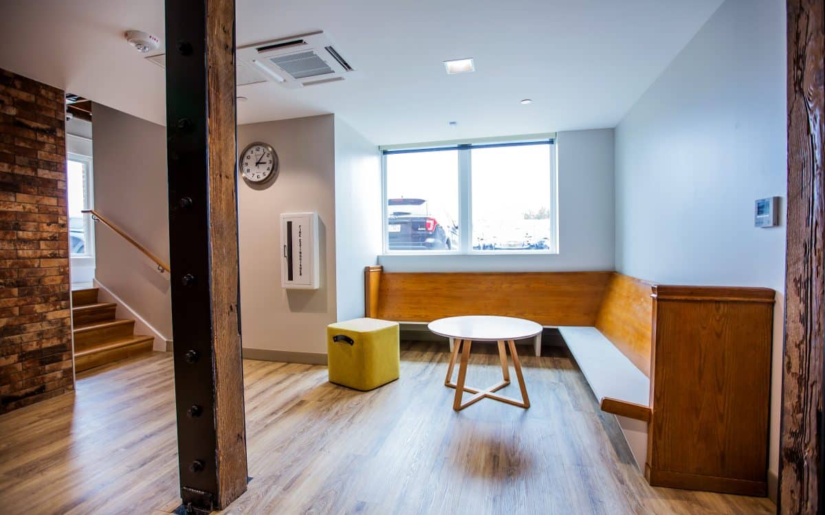 A small office with wooden floors and a bench made of wood.