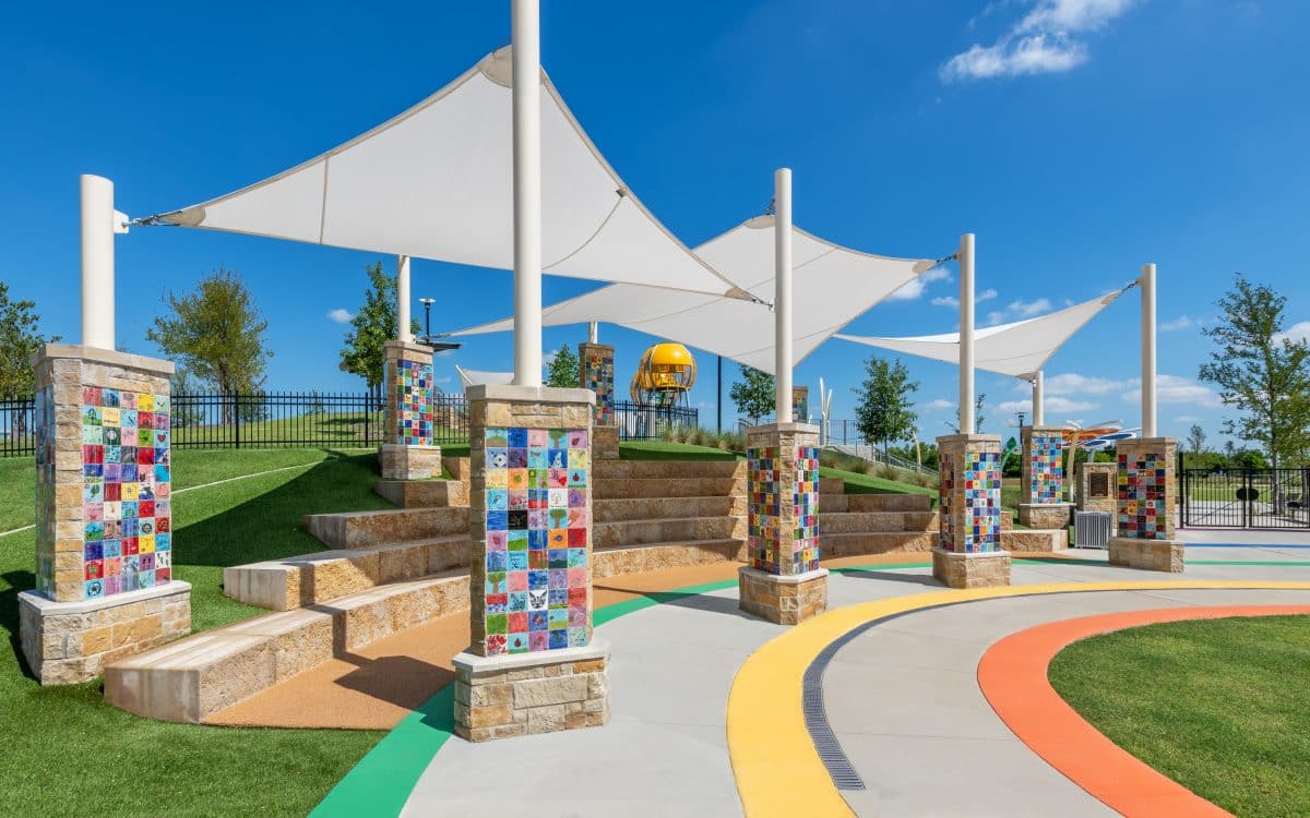 A colorful playground with benches and umbrellas has been built in the park construction.