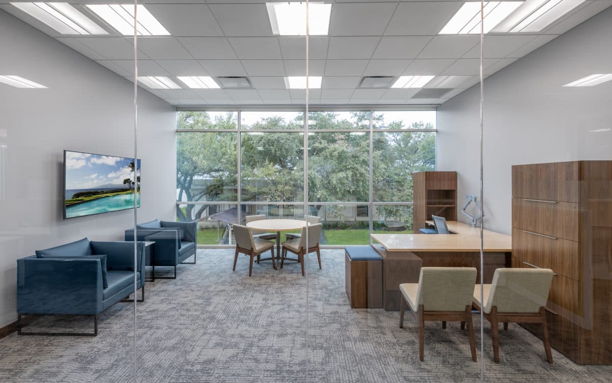 A modern office with a glass wall and chairs, perfect for municipal construction projects.