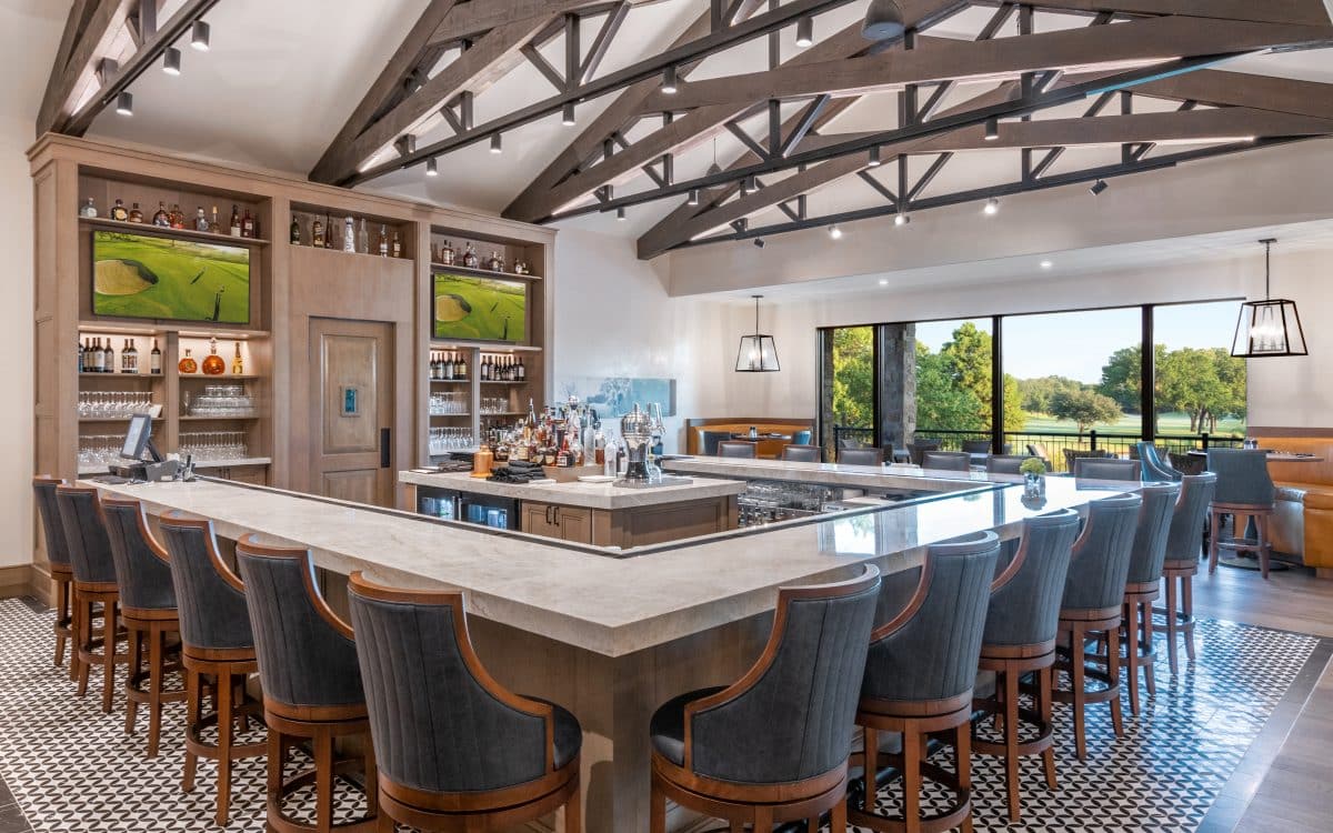 A large dining room with wood beams and a bar.