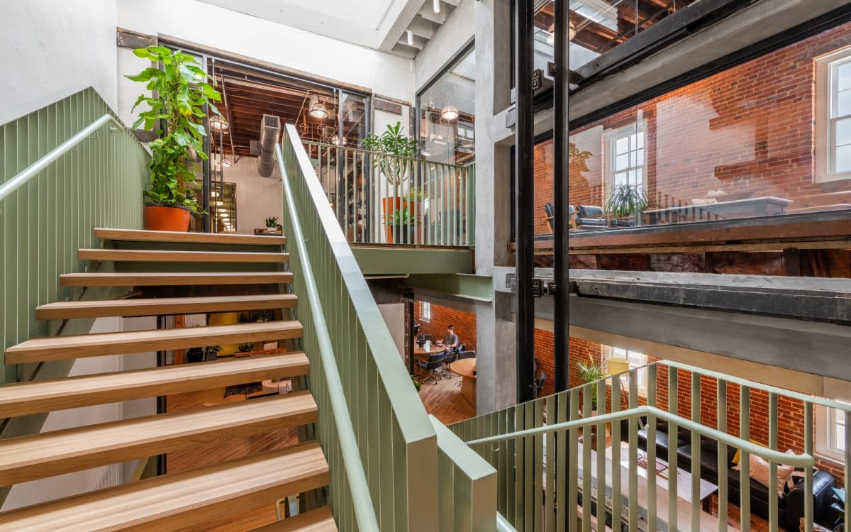 A staircase leading up to an office with plants and greenery.