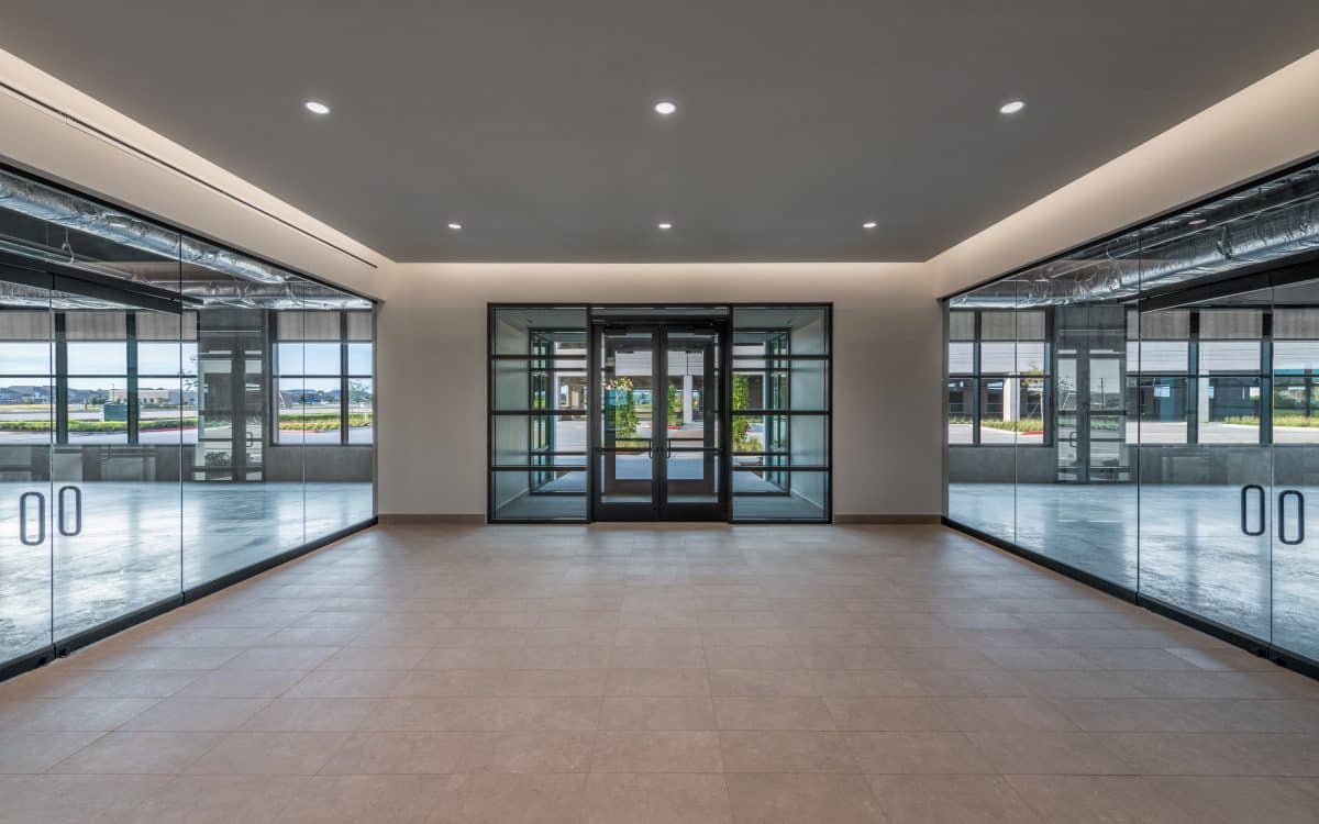The lobby of a large office building with glass doors.
