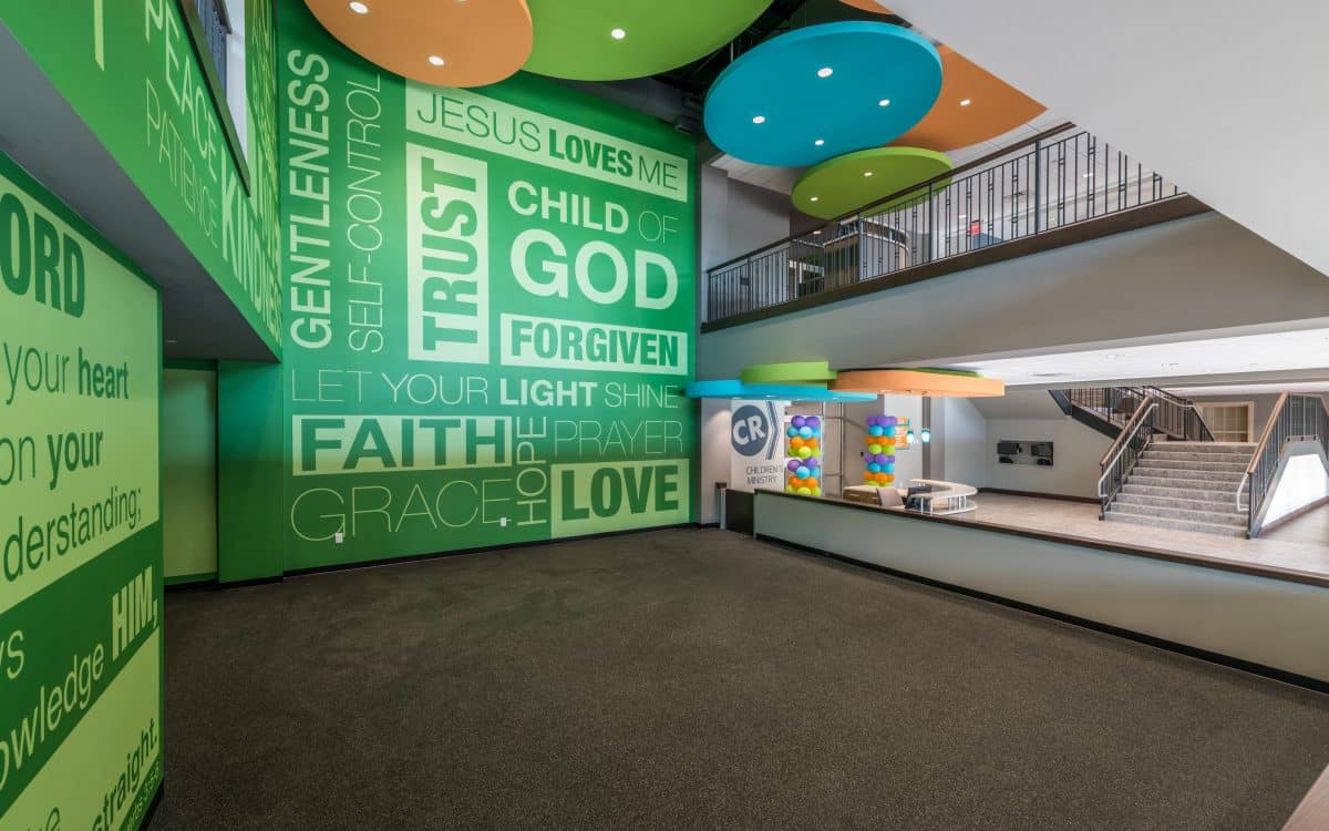 The lobby of a church with a colorful mural on the wall.