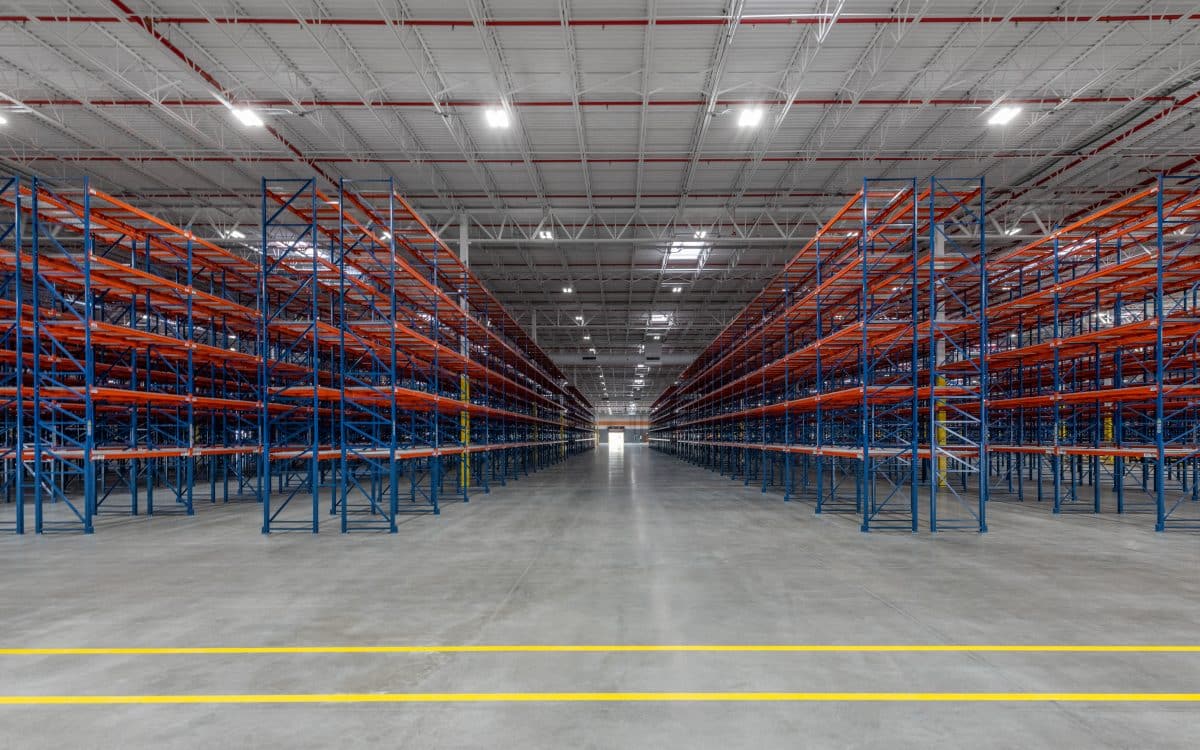 A large warehouse with blue and red shelving.