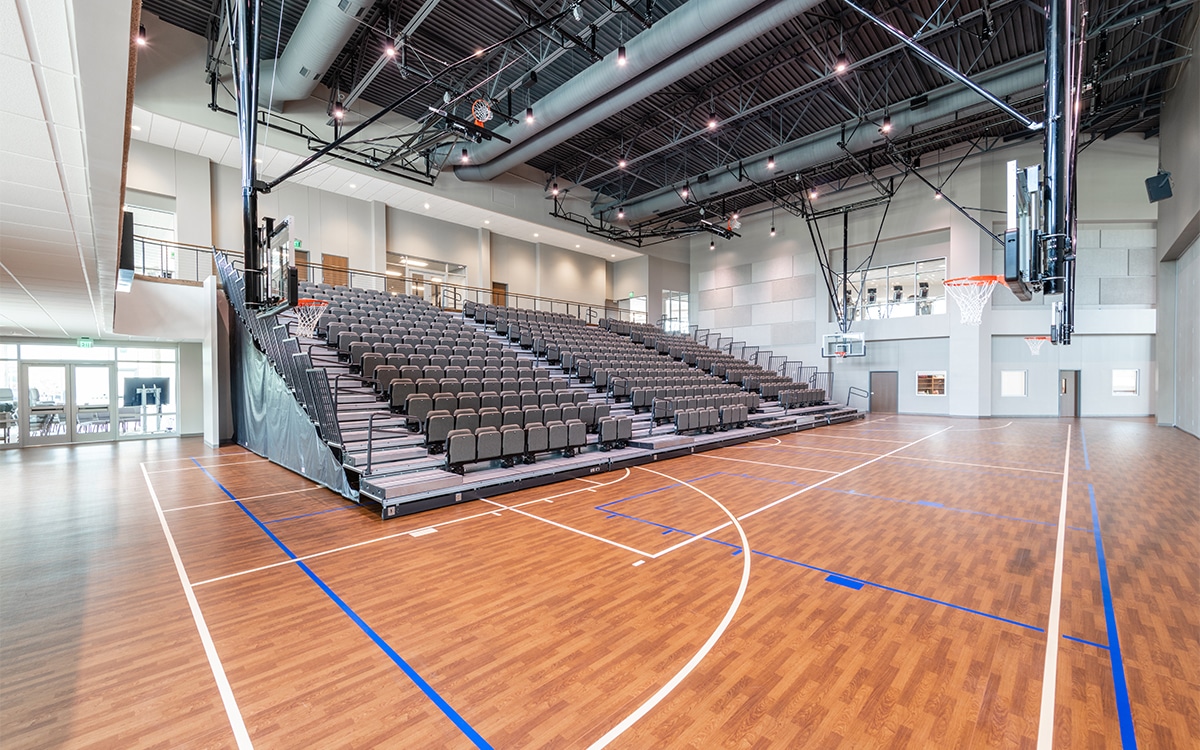 A basketball court with wooden floors and wooden seats.