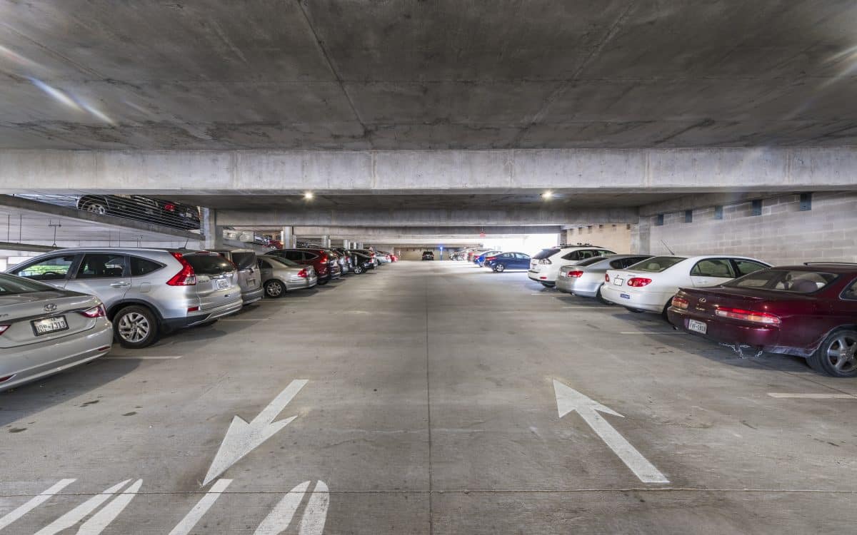 A parking garage with a lot of cars parked in it.