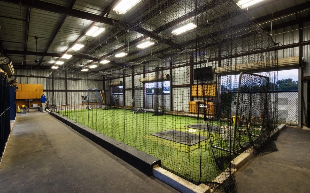 A baseball batting cage in a warehouse.