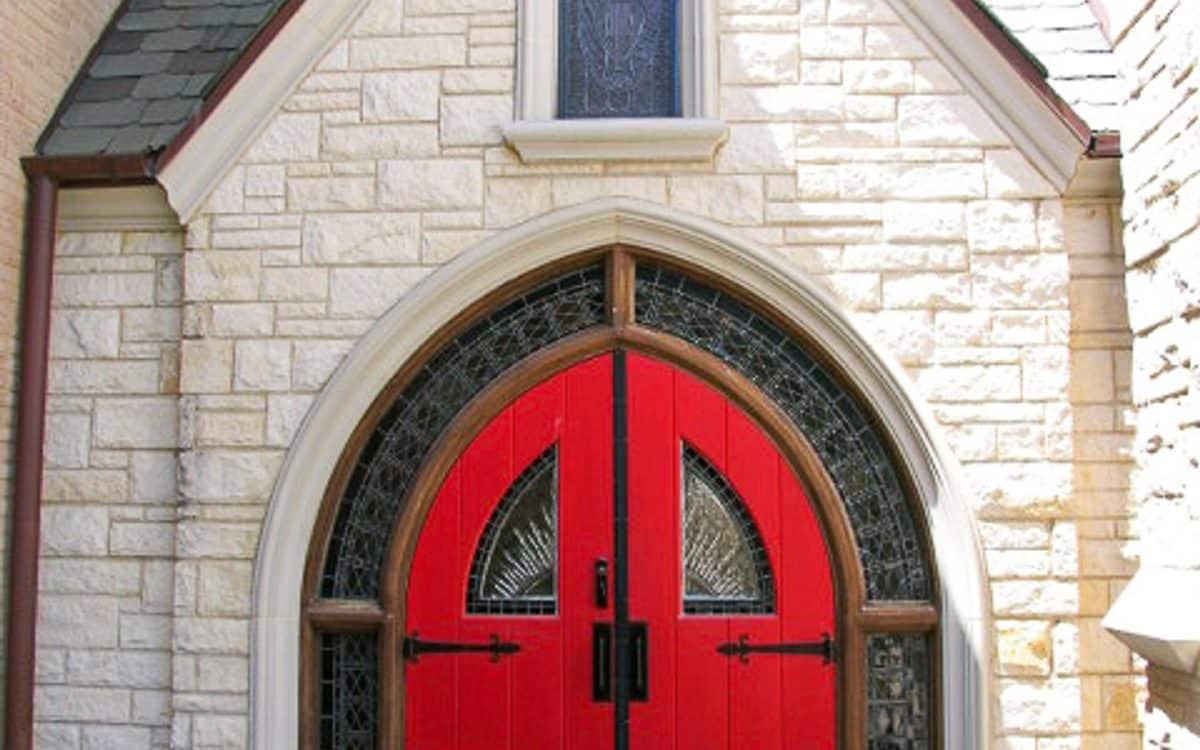 A stone building with a red door.