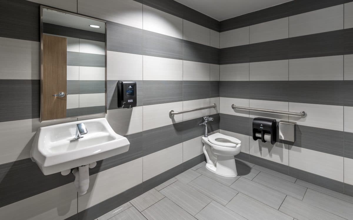 A bathroom with gray and white striped walls.