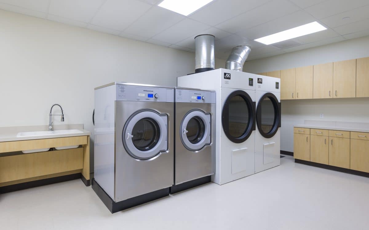 A laundry room with two washers and dryers.