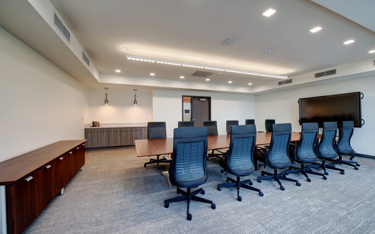 A conference room with a large table and chairs.