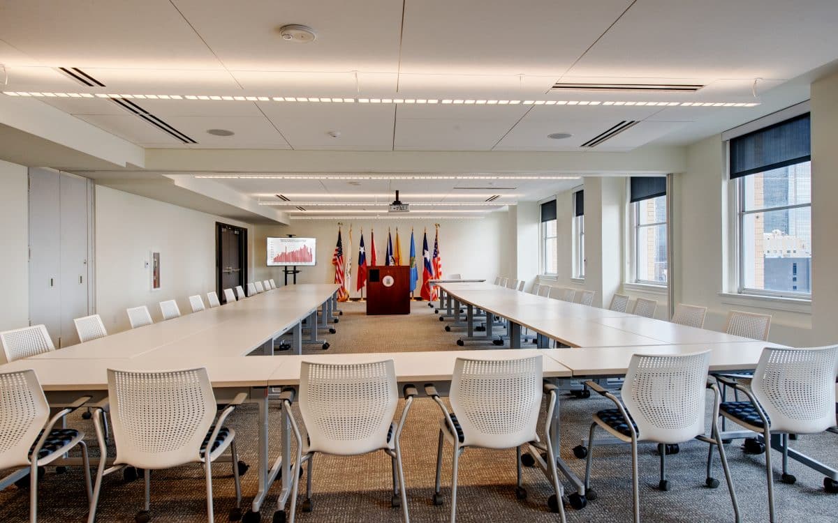 A conference room with a long table and chairs.