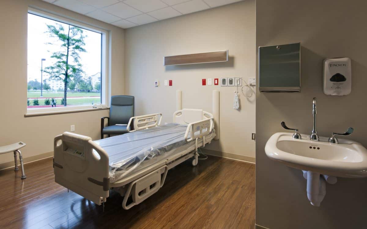 A hospital room with a bed and a sink.