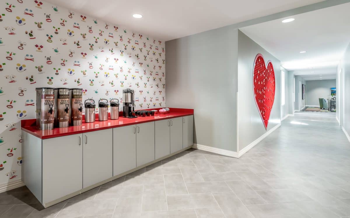 A hallway with a coffee station and red heart wall paper.