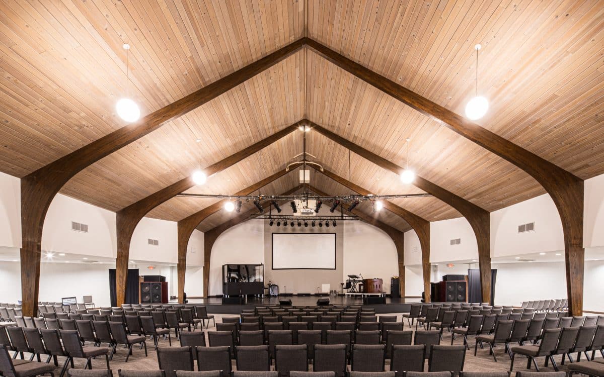 A large auditorium with wooden ceilings and rows of chairs.