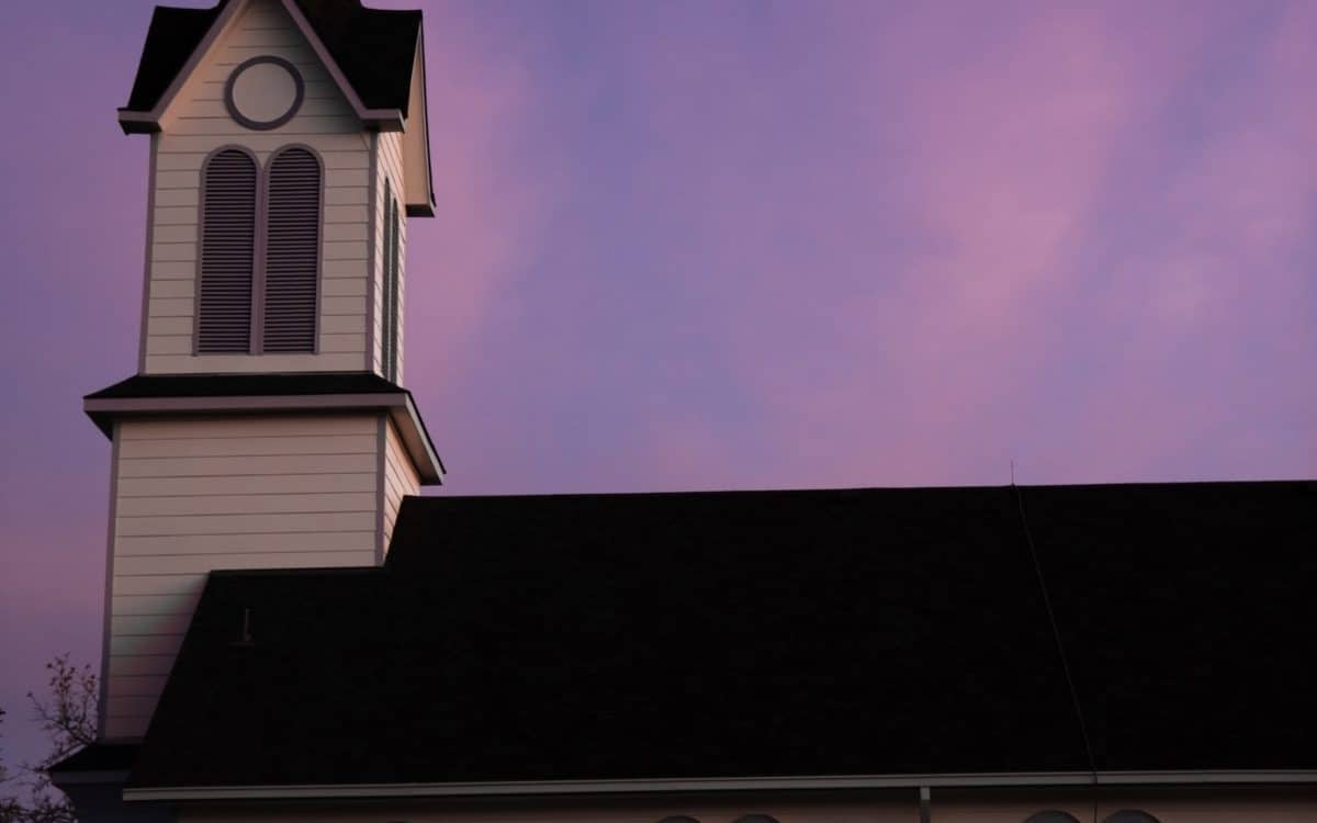 A church with a steeple at dusk.