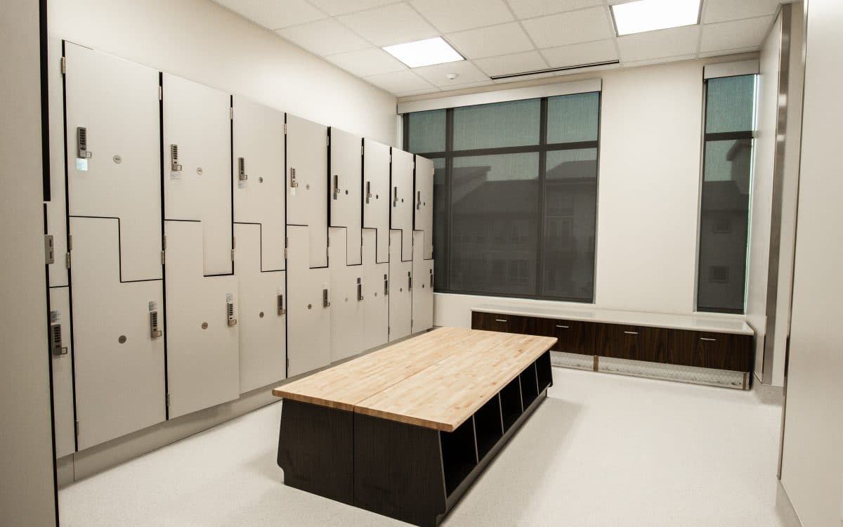 A locker room with many lockers and a table.