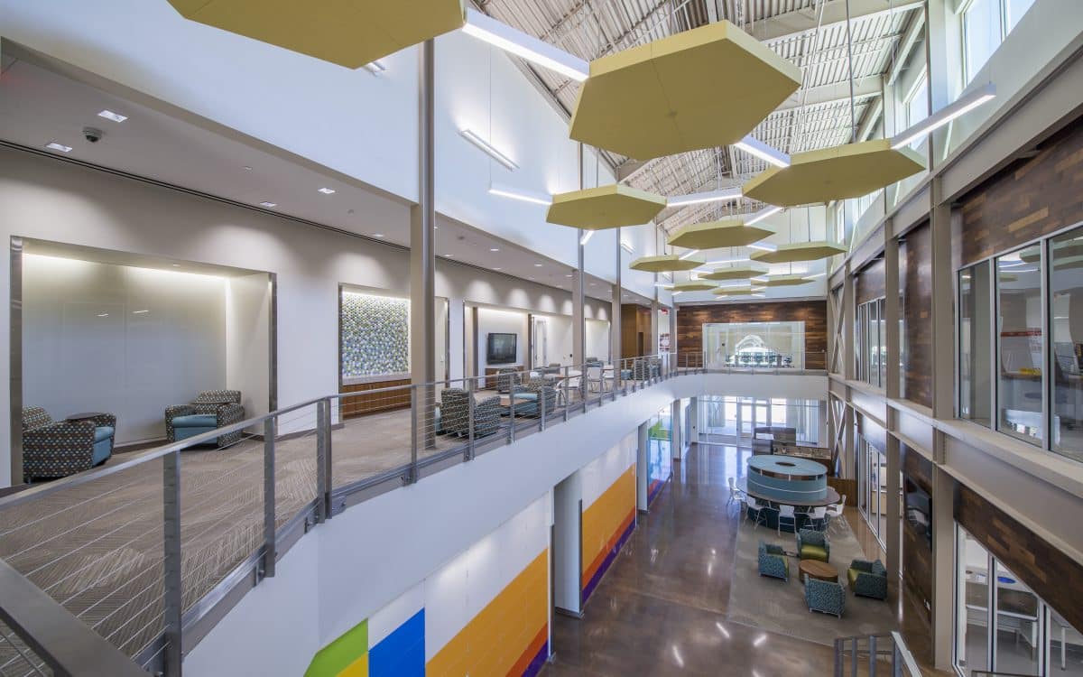 The lobby of a large office building with colorful ceilings.