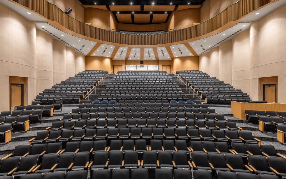 The Ursuline auditorium features rows of black seats.