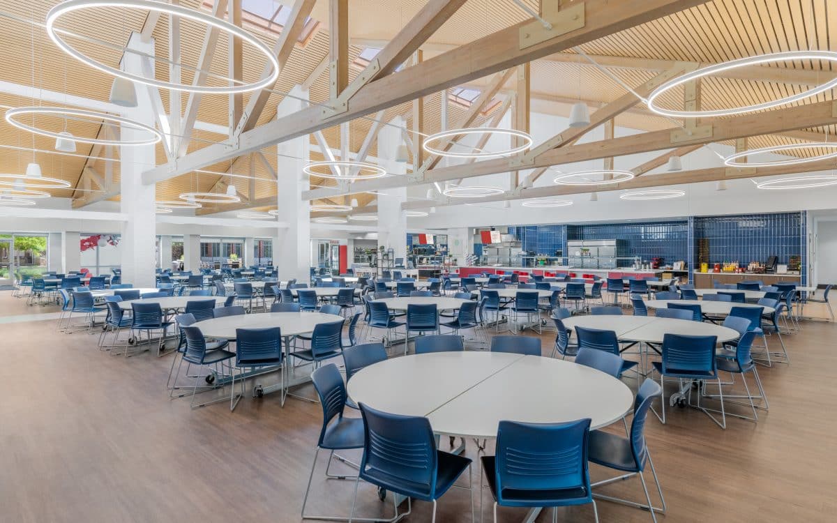 A large Ursuline cafeteria with blue tables and chairs.