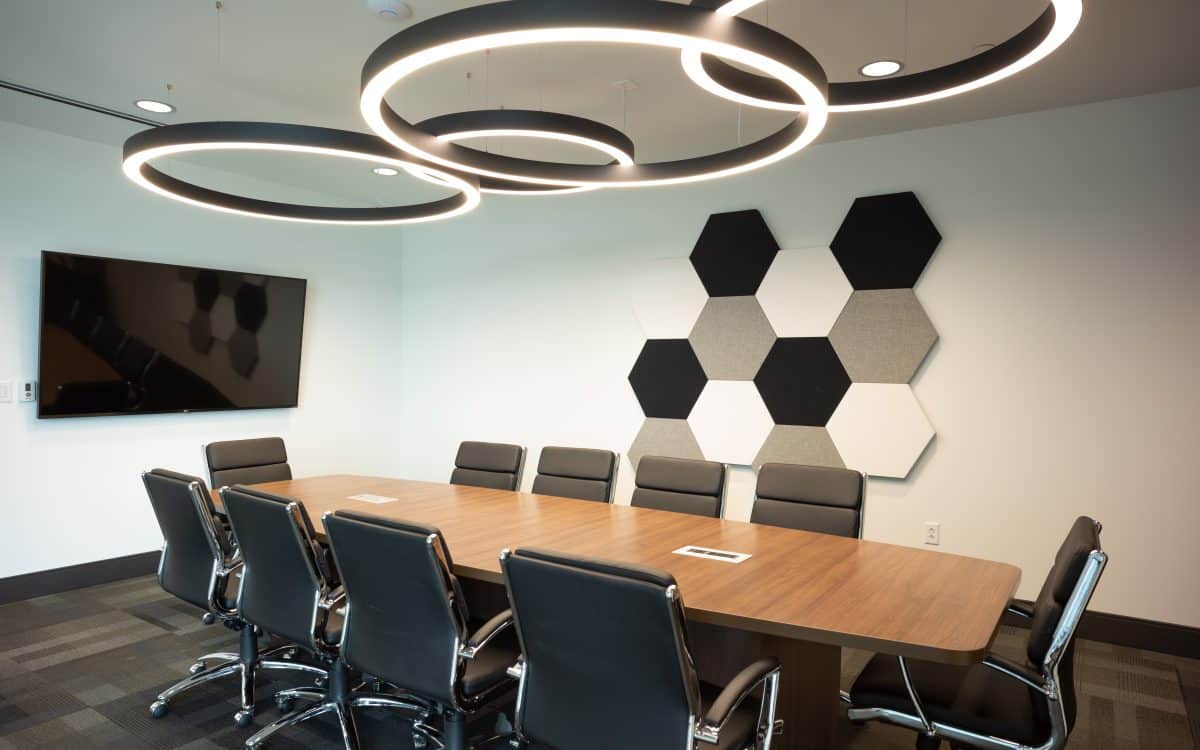 A conference room with black and white chairs and a tv.