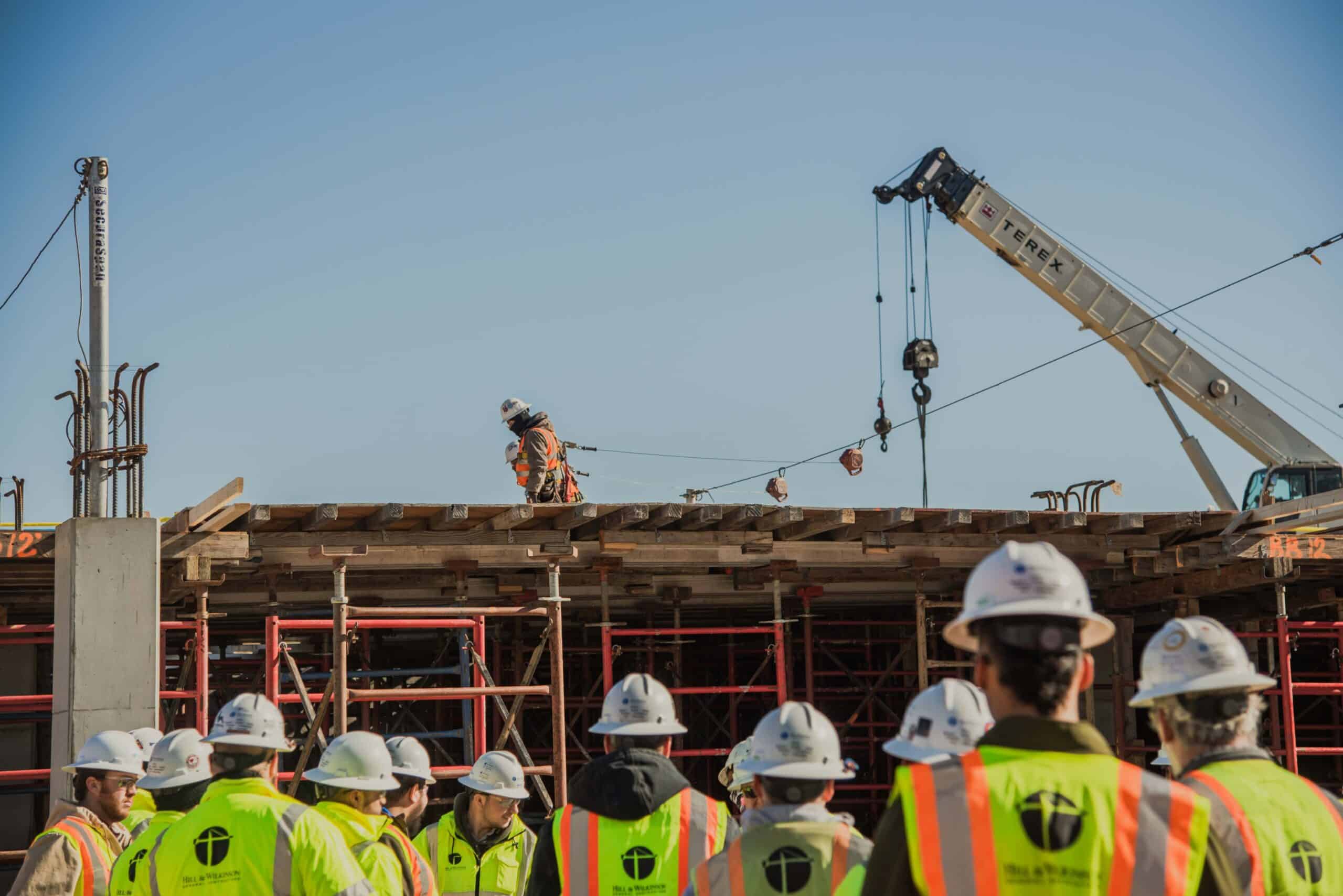 people wearing PPE standing in front of a construction building