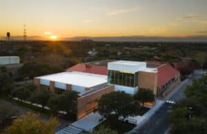 An aerial view overlooking a college athletic facility building at sunset